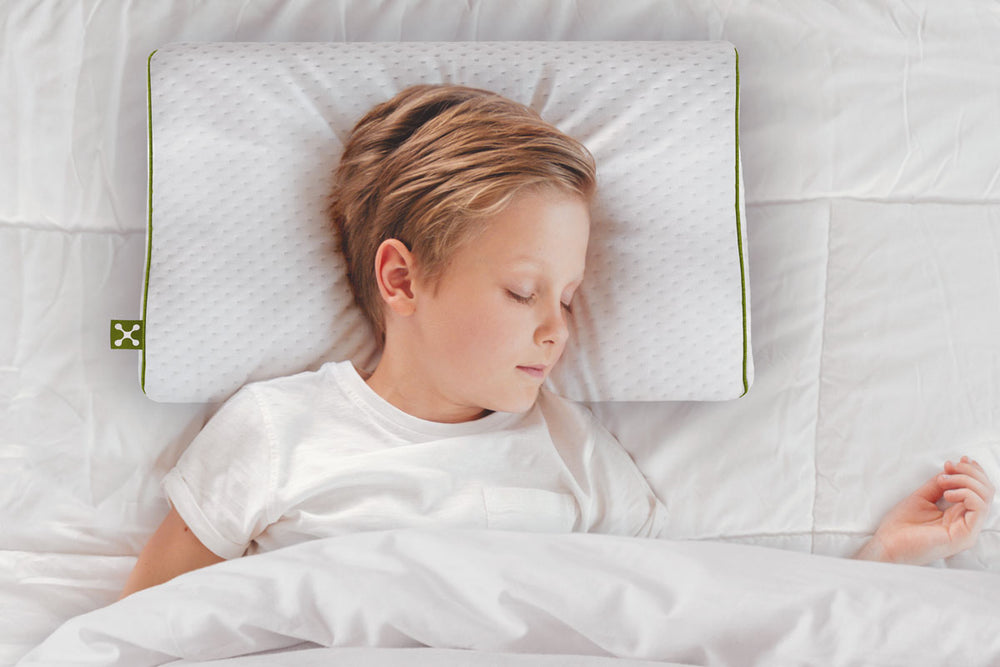 Blonder Junge schläft ruhig auf einem smart KIDS ERGONOMIC PILLOW, dem ergonomischen Nackenkissen speziell für Kinder
